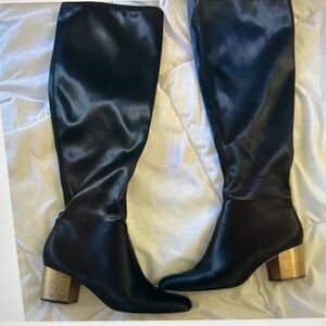 Satin crafts an essentiall over-the-knee boots.